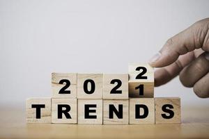 blocco cubo di legno che lancia a mano per cambiare il concetto di tendenza dal 2021 al 2022. foto