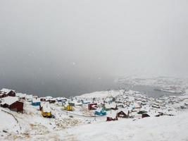 Strom di neve sul piccolo lbeautiful villaggio, vista aerea da drone qaqortoq, Groenlandia europa foto