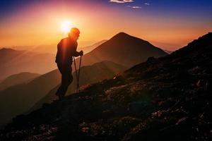 turista in montagna al tramonto foto