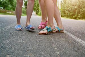 i piedi dei bambini in pantofole sull'asfalto foto