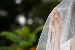 sfondo del matrimonio, la mano della sposa sotto il velo foto