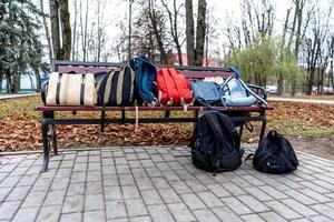 borse e zaini abbandonati su una panchina del parco. foto