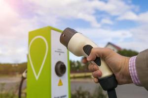 cavo di ricarica per auto elettriche nel primo piano della mano dell'uomo foto