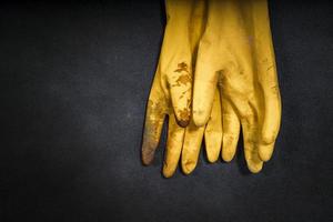 guanti di gomma gialli usati su sfondo nero foto