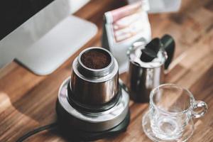 caffè macinato finemente e caffettiera vintage moka su tavola di legno in ufficio a casa foto