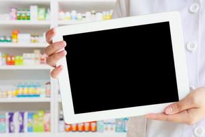 farmacista che mostra tablet computer in farmacia foto