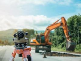 contagiri o teodolite per attrezzature da geometra con sfondo di un cantiere stradale foto