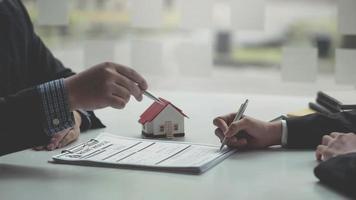 l'agente immobiliare o il responsabile delle vendite ha proposto termini e condizioni ai clienti che firmano contratti di acquisto di casa con assicurazione, accordo per firmare il concetto di contratto di acquisto. foto