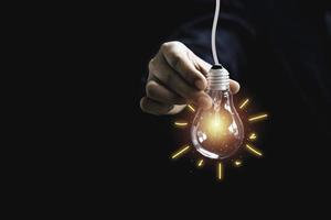 uomo d'affari che tiene lampadina incandescente con pittura a raggi di illustrazione. è innovazione di idea di pensiero creativo e concetto di brevetto. foto