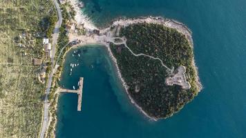 vista aerea del drone di una bellissima isola semi in mezzo al lago con una fortezza. bei colori in acqua e paesaggio incredibile. viaggiare per il mondo e trovare le meraviglie. le vacanze stanno arrivando. foto