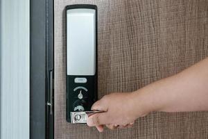 la mano della donna tiene la maniglia della porta mentre apre una porta per l'accesso al condominio. porta elettrica con codice tastiera per sistema di sicurezza in camera appartamenti. porta elettronica per ingresso-uscita edificio. foto