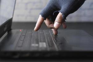 mano di hacker che ruba dati dal laptop dall'alto verso il basso foto