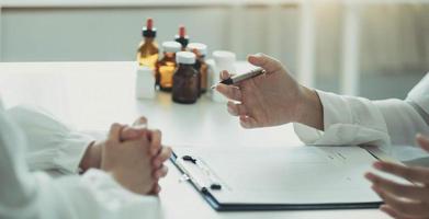 medico che tiene i risultati dei test e consulta il paziente presso l'ufficio medico della scrivania, concetto di professionalità sanitaria della clinica ospedaliera foto