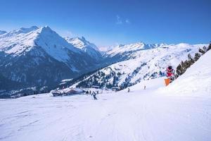 sciatori che sciano sulle montagne innevate contro il cielo foto