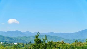 le montagne sono piene di verde contro il cielo blu. foto