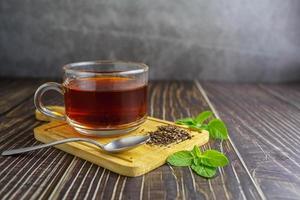 tè in tazza di vetro su fondo di legno foto