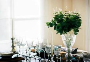 tavolo da pranzo decorativo con vetro, candelabro e fiore foto