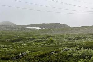 nebbia, nuvole, rocce e scogliere sulla montagna veslehodn veslehorn, norvegia. foto