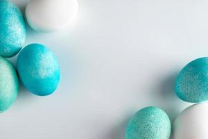 cornice di uova di Pasqua blu su sfondo chiaro. foto