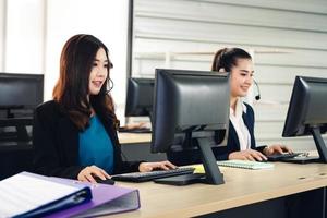 giovane donna asiatica del personale di affari che lavora con la cuffia ed il computer per il supporto. foto