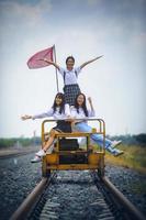 gruppo di adolescenti asiatici sorridenti con la faccia felice sul binario ferroviario foto
