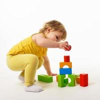 bambina che gioca con blocchi di giocattoli colorati foto