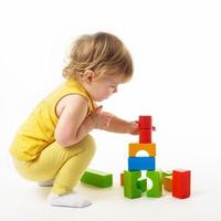 bambina che gioca con blocchi di giocattoli colorati foto