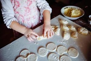 ragazza panettiere in cappello da cuoco in cucina foto