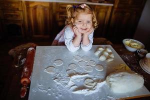 ragazza panettiere in cappello da cuoco in cucina foto