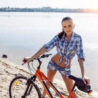 donna in bicicletta in spiaggia foto