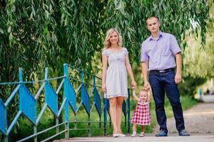 felice madre, padre e figlia nel parco foto