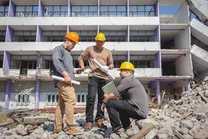 team di ingegneri e lavoratori che controllano il progetto per il piano di costruzione di emolizione e ispezionano il sito. foto