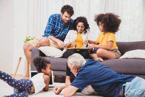 bella casa famiglia stare insieme in soggiorno padre madre e nonno che giocano con la figlia mescolano razza. foto