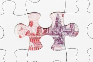 banconota riel cambogiana nascosta sotto il concetto finanziario di puzzle foto