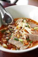 Chiuda sulla tagliatella di minestra piccante tailandese con carne di maiale foto