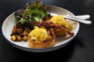 uova Benedict bacon colazione sul tavolo foto