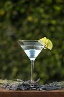 vodka o gin cocktail con lavanda su sfondo verde foto