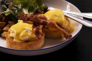 uova Benedict bacon colazione sul tavolo foto