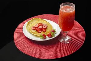 fragole e frittelle con sciroppo sul piatto bianco foto