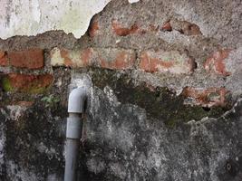 il muro della casa è danneggiato finché non si vede il tubo dell'acqua foto