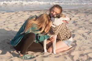 donna gioca con il cane sulla spiaggia foto
