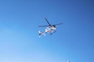 elicottero della polizia che vola sopra contro il cielo blu in una giornata di sole foto