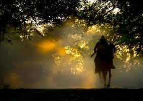 cowboy a cavallo contro un bel tramonto, cowboy e cavallo alle prime luci, montagna, fiume e stile di vita con sfondo di luce naturale foto