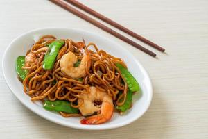 noodles di yakisoba saltati in padella con piselli e gamberi foto