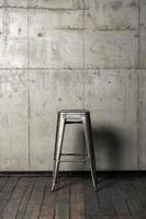 sedia in metallo sullo sfondo di un muro di cemento