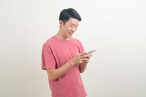 giovane uomo asiatico che usa o parla smartphone e telefono cellulare con faccia felice foto