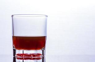 bicchiere di whisky su un tavolo di vetro foto