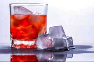 bicchiere di whisky e ghiaccio su un tavolo di vetro