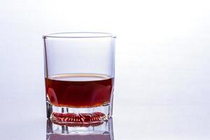 bicchiere di whisky su un tavolo di vetro foto