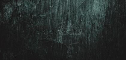 muro pieno di graffi. struttura di cemento grungy per sfondo, parete scura spaventosa. parete nera foto